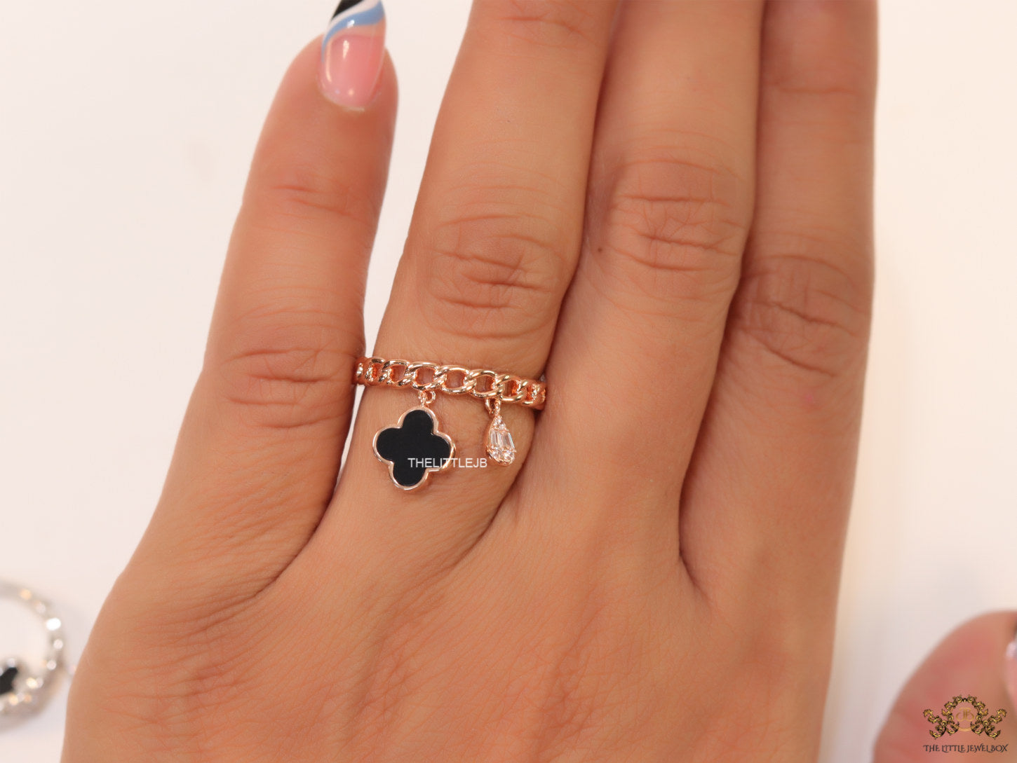 Rose gold plated link chain ring with black clover and cz drop